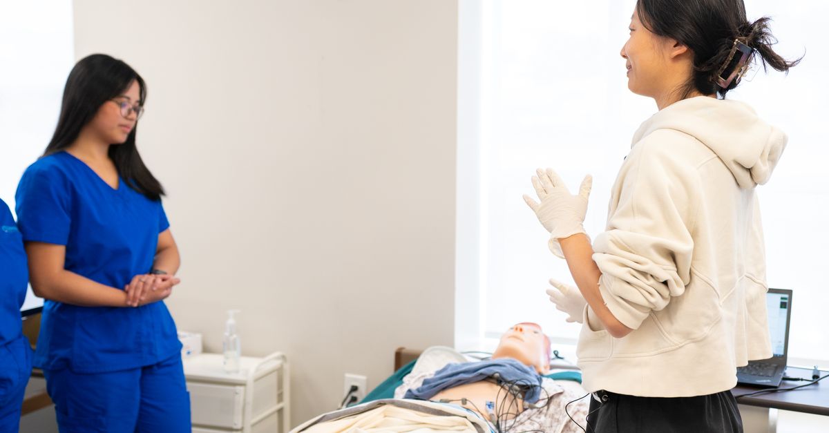 A nurse lecturer teaching students in a university classroom