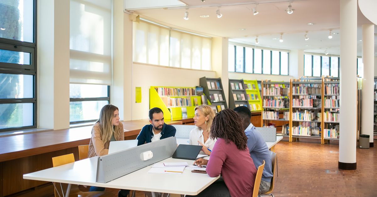 A diverse group of university staff and students in a meeting room