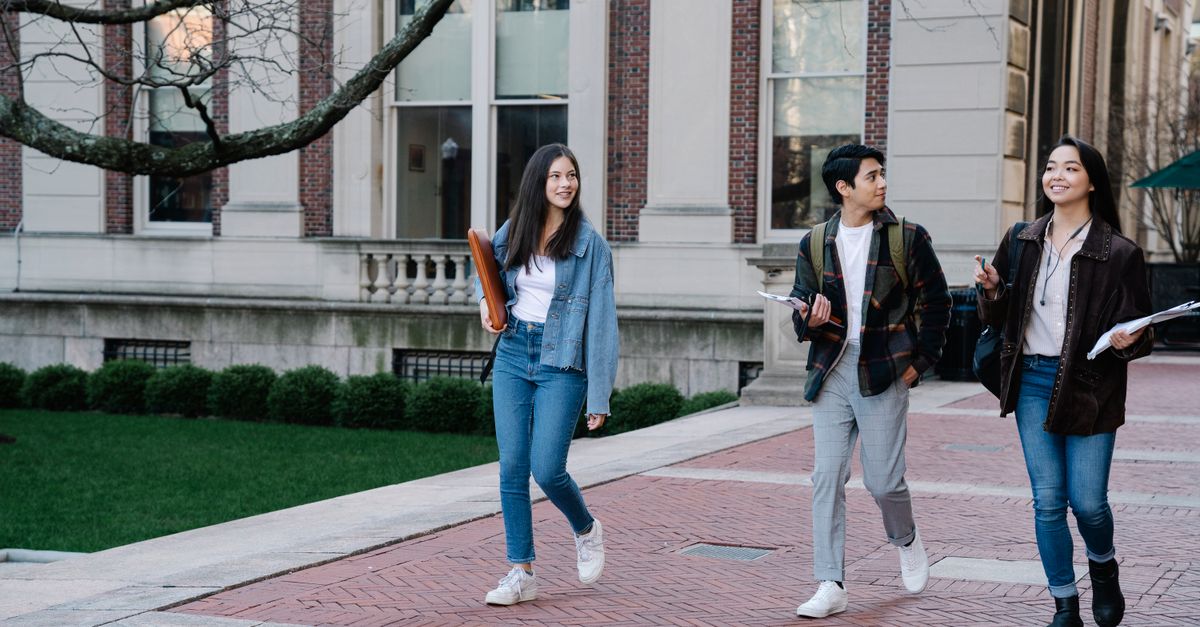 Students and staff walking across a British university campus